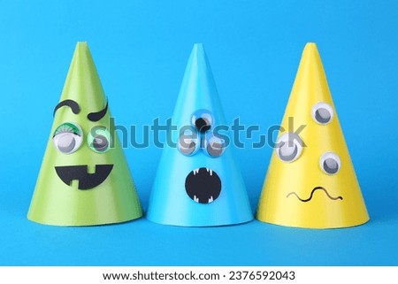 Spooky paper monsters on light blue background. Halloween decoration