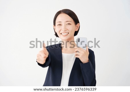 Asian middle aged businesswoman with the smartphone thumbs up gesture in white background