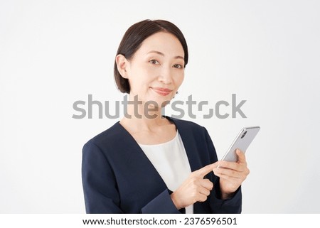 Asian middle aged businesswoman using the smartphone using in white background