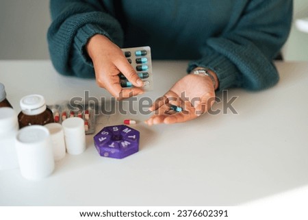 Women organizing his medication into pill dispenser. female taking pills from box. Healthcare and concept with medicines. Medicaments on table Royalty-Free Stock Photo #2376602391