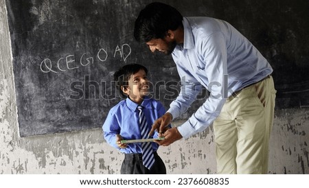 Indian teacher teaching to rural school student in classroom, Typical scene in a rural or small village school in India Royalty-Free Stock Photo #2376608835