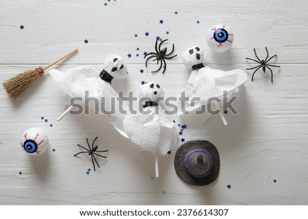 Tasty lollipops and Halloween decor on light wooden background