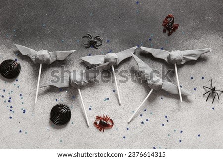 Composition with tasty lollipops for Halloween party on grey background