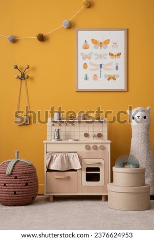 Cozy kid room interior with mock up poster frame, children kitchen, plush lama, braided basket, beige boxes, colorful garland, toys, toy camera, cup and personal accessories. Home decor. Template.
