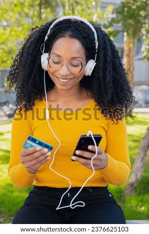 vertical photo happy black woman with credit card and smartphone