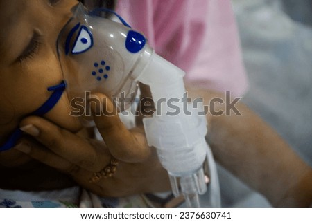 Doctor and nurse use giving medicine mask bronchodilator breathing treatment and breathe oxygen for treat cure thai baby girl sick ill flu in patient room of hospital clinic in Bangkok at Thailand Royalty-Free Stock Photo #2376630741