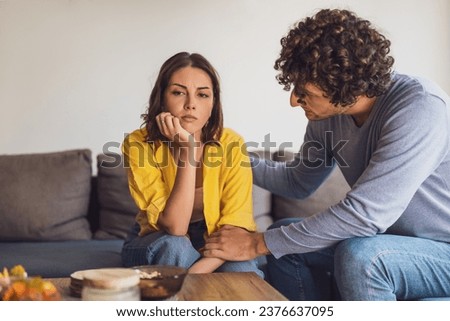 Man and woman are sitting at sofa and arguing. Relationship problems. Royalty-Free Stock Photo #2376637095