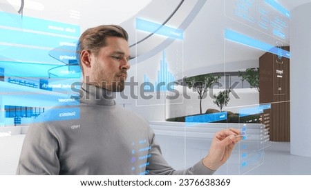Handsome Man Standing in a Futuristic Virtual Space, Interacting with an Augmented Reality Hologram with Business Data, Financial Reports, Stock Market Statistics, Infographics and Charts
