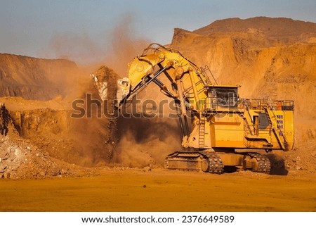 Mining excavators are heavy construction machines used in various mining operations to dig, scoop, and load large quantities of materials, such as ore, overburden, or waste rock.  Royalty-Free Stock Photo #2376649589