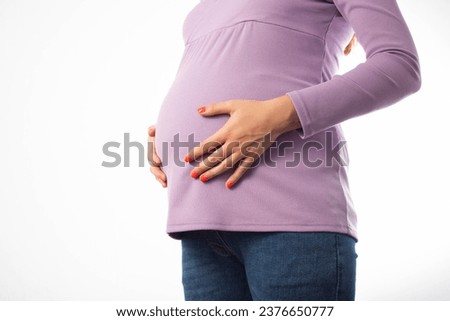 Pregnant girl holding her belly on a white background. Concept of intestinal and vaginal infections during pregnancy. Infection of the fetus through the placenta. Copy space for text Royalty-Free Stock Photo #2376650777