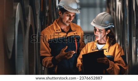 Warehouse inventory management in metalwork factory with engineer conduct storage check and quality control assessment on cylinder rolled metal for civil engineering project. Panorama Exemplifying Royalty-Free Stock Photo #2376652887