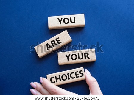 You are Your Choices symbol. Concept words You are Your Choices on wooden blocks. Beautiful deep blue background. Businessman hand. Business and You are Your Choices concept. Copy space.