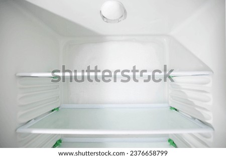 Ice and snow build up on the back wall of the refrigerator. Refrigerator failure, freon leak, temperature sensor defective. Royalty-Free Stock Photo #2376658799