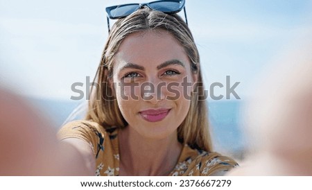 Young blonde woman smiling confident make selfie by camera at seaside