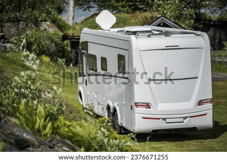 Modern Three Axle Full Size Full Integral Camper Van with Satellite Dish on the Roof Royalty-Free Stock Photo #2376671255
