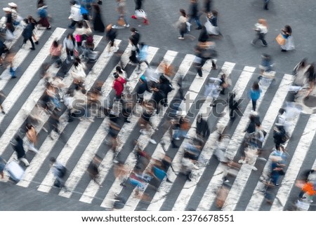Birds eye view and blurred motion of pedestrians on crosswalk in rush hour in Tokyo, Japan, creating abstract image Royalty-Free Stock Photo #2376678551