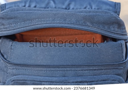 one black orange fabric bag with open plastic zip