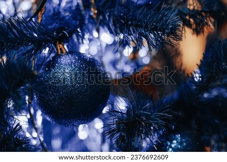 Neon blue Christmas tree decorated with shiny Christmas ball. Magic atmosphere and festive decorations
