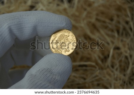 An old French gold coin in a numismatist's hand. 20 francs 1885. High quality photo