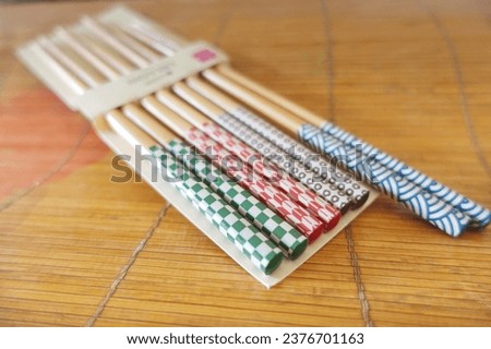 Bamboo chopsticks with cute colored printed decoration isolated on brown background.