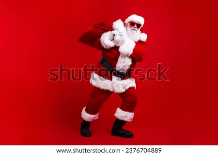 Photo of nice cool senior man wear santa claus clothes hands hold sack bag new year night miracle isolated on red color background