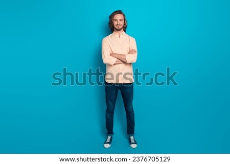 Full length photo of pleasant positive guy with long haircut wear stylish shirt holding arms crossed isolated on blue color background