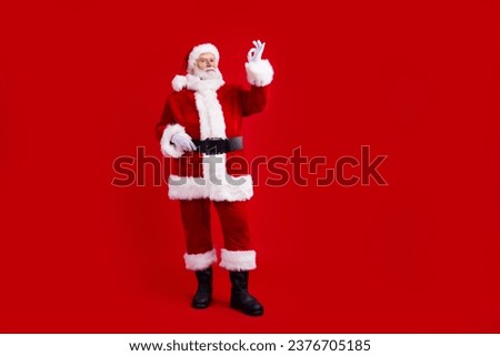 Full length photo of retired confident man santa claus recommend new year offer benefit promo empty space isolated on red color background