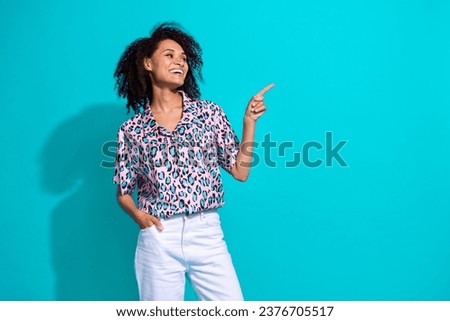 Photo of adorable satisfied cute girl wear trendy outfit presenting cool offer poster mockup empty space isolated on cyan color background