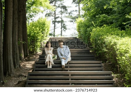 A loving couple are sitting on the steps of the park and taking wedding pictures for their wedding.