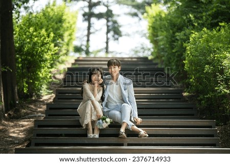 A loving couple are sitting on the steps of the park and taking wedding pictures for their wedding.