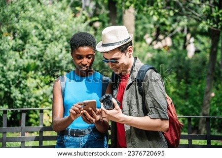 Multi-ethnic tourists using a mobile while visiting a city