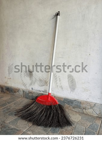 Palm fiber broom to sweep the floor.