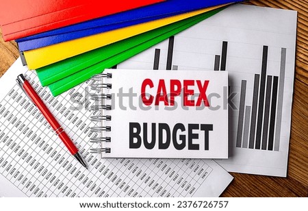 CAPEX BUDGET text on a notebook with pen, folder on a chart background