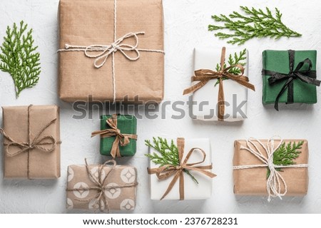 Craft gift boxes on a white background, thuja branches. Concept for Christmas holidays and DIY eco gifts. Postcard, layout. Boxing Day. Royalty-Free Stock Photo #2376728231