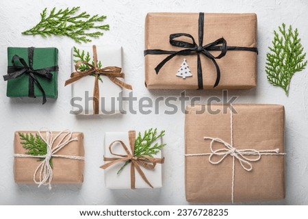 Gift boxes on a white background and thuja branches. Concept of Christmas holidays and gifts. Postcard, layout. Boxing Day.