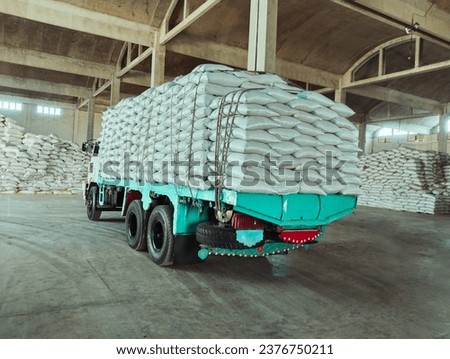 Truck loaded with bags white sacks in a warehouse godown factory stocks supply  camion charge de sacs image photo  Royalty-Free Stock Photo #2376750211
