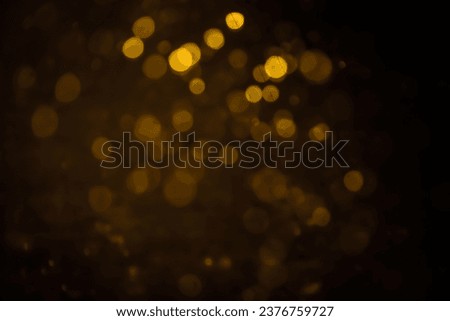 Blurred photo with golden dots visible glittering, shining brightly look and feel luxurious Suitable for use as a wallpaper showing luxury and taste.