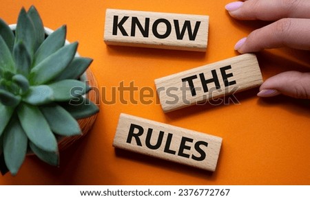 Know the rules symbol. Wooden blocks with words Know the rules. Beautiful orange background with succulent plant. Businessman hand. Business and Know the rules concept. Copy space.