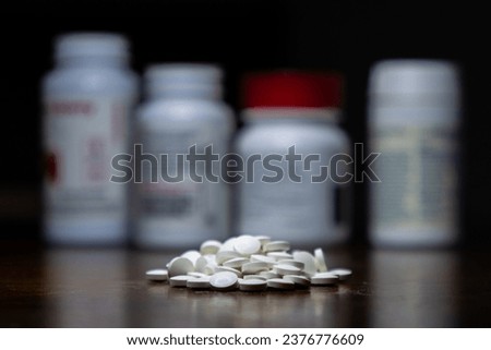 Pile of pills in front of medical prescription bottles