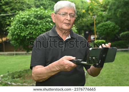 Portrait of Indian senior people making documentary from phone  in the park