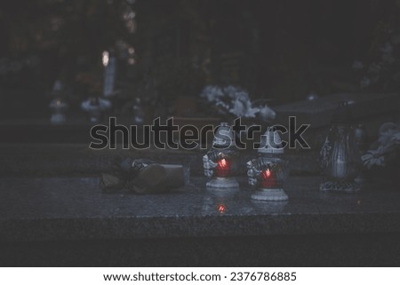 grave decorated with lantern, candles, flowers during All souls day, sad and peaceful atmosphere Royalty-Free Stock Photo #2376786885