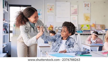 Teacher woman, high five boy and classroom with achievement, success and mentorship for learning. Education, development and students with goals, knowledge and books with celebration, school and desk Royalty-Free Stock Photo #2376788263