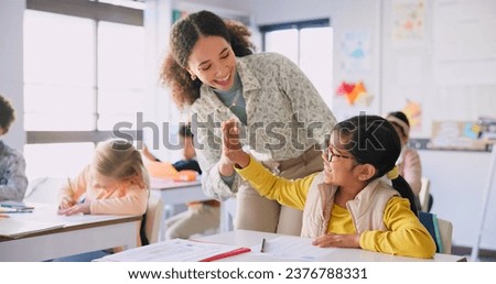 Teacher woman, high five girl and classroom with achievement, success and mentorship for learning. Education, development and students with goals, knowledge and books with celebration at school desk Royalty-Free Stock Photo #2376788331