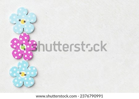 Colored pastel background with decorative colorful wooden buttons shaped like flowers, with place for your text and design. Creative background concept. Top view