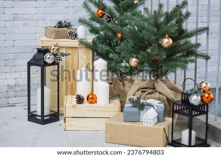 Christmas tree, candles and gift boxes on the background of a brick wall