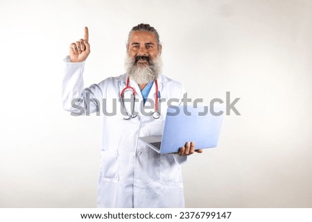 A doctor working with a laptop pointing his finger with a smiling face on a white background
