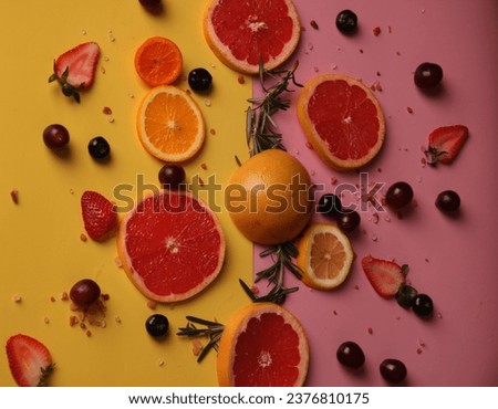 Fruits sliced on a pink and yellow background for advertisement