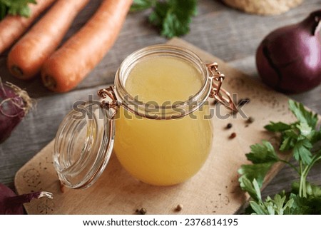 A jar of chicken soup or bone broth on a wooden table