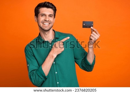 Photo of young man direct finger plastic credit payment card money maker create content for  isolated on orange color background