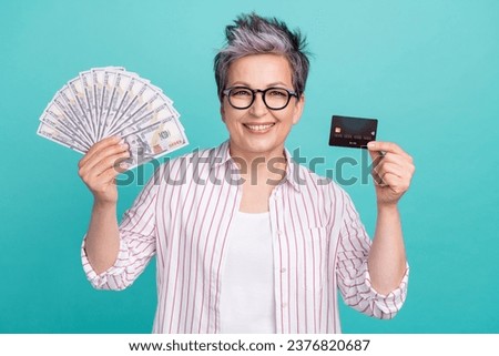 Photo advert of cheerful business lady receive payment online bank account hold plastic card cashback isolated on cyan color background